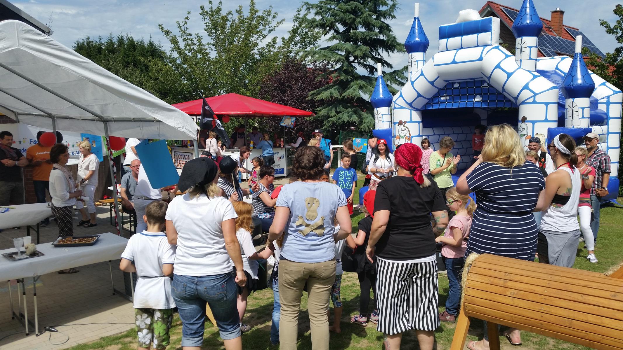 Vor der Hüpfburg stehen einige Kinder und Erzieher