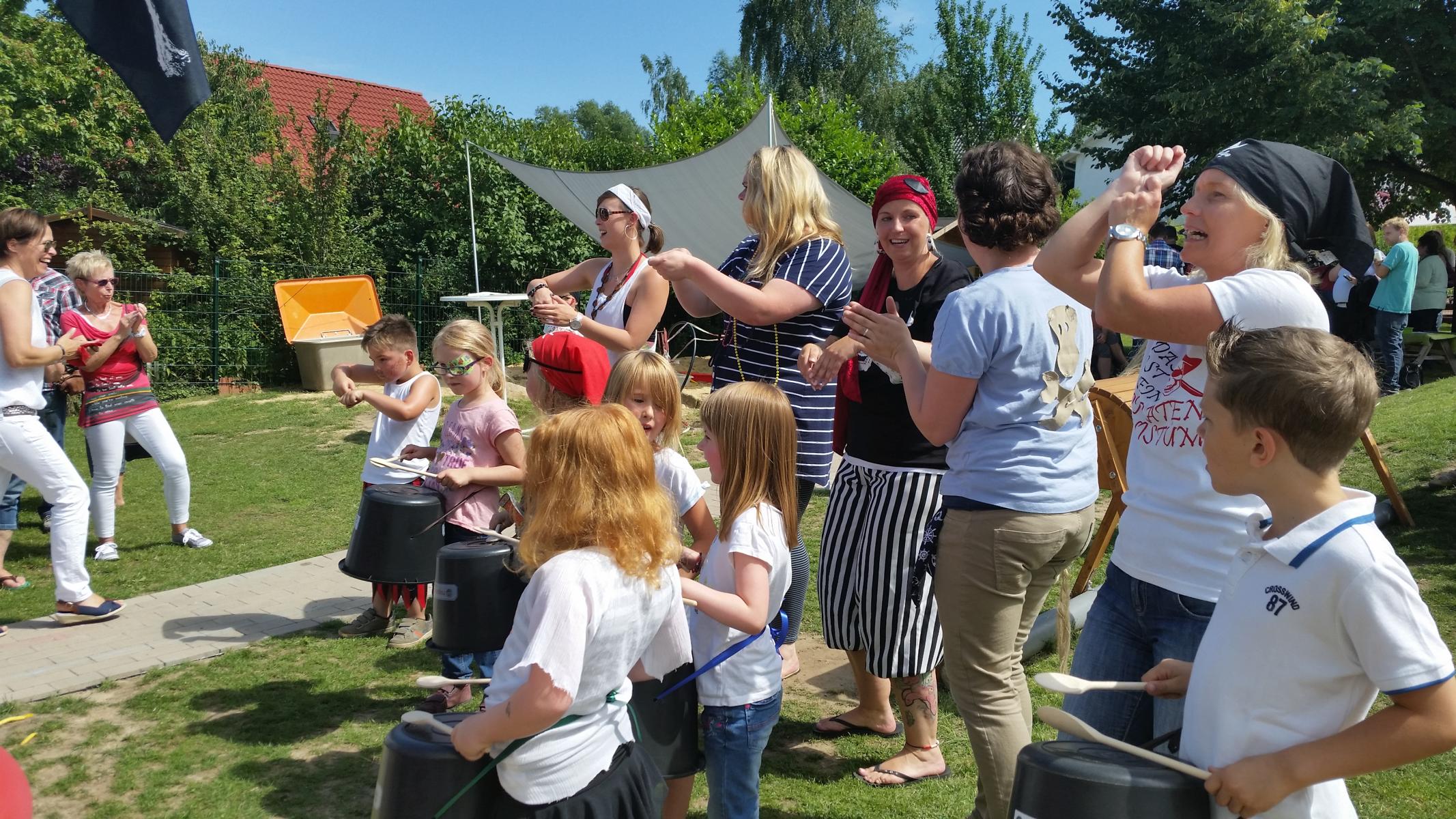 Die Erzieher sind als Piraten verkleidet und die Kinder machen Musik auf Eimern