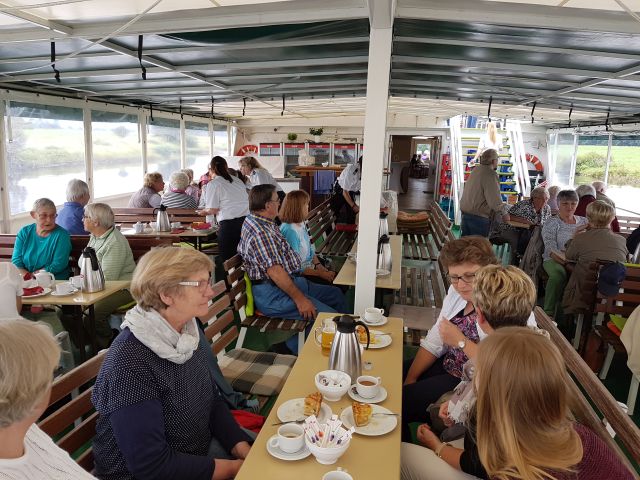 Einige Leute sitzen im Außenbereich und trinken Kaffee