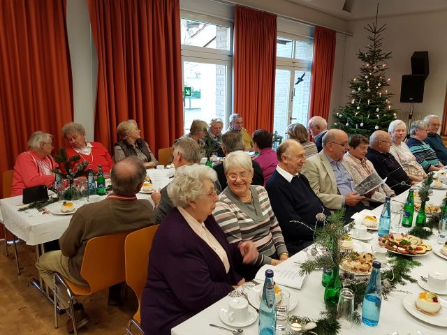 Senioren die sich am Tisch miteinander unterhalten