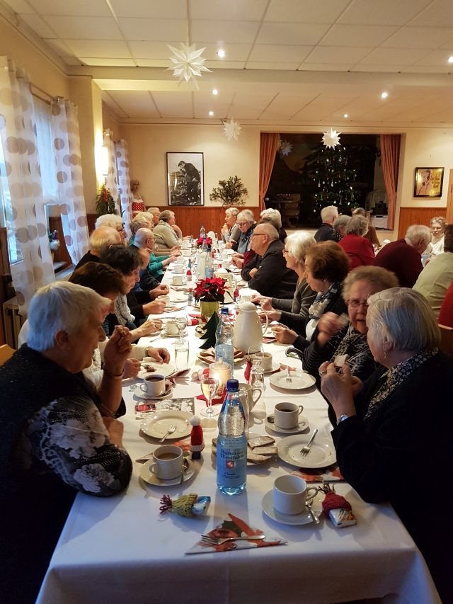 Ein langer, geschmückter Tisch mit Menschen